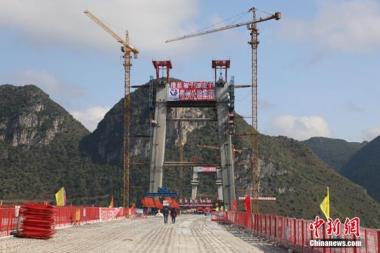 11月22日，正在建設中的峰林特大橋。當日，隨著1470噸裝配化預制中橫梁提升到位，貴州省黔西南布依族苗族自治州興義環(huán)城高速公路峰林特大橋4號主塔中橫梁成功吊裝，由此刷新了山區(qū)峽谷橋梁預制吊裝混凝土構件重量世界記錄。峰林特大橋是屬全線控制性工程。大橋跨越馬嶺河峽谷，全長1163米，主跨采用550米懸索橋，橋面離谷底364.2米，是中國山區(qū)第一座大跨徑鋼混疊合梁懸索橋。中新社記者 瞿宏倫 攝